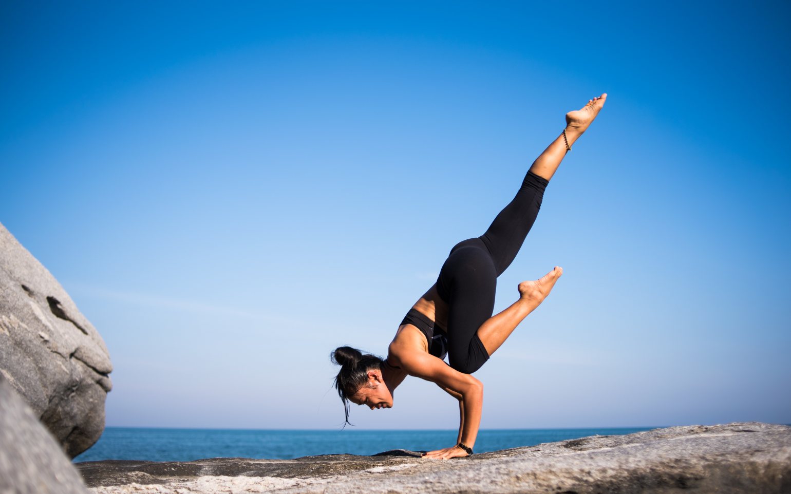 Woman doing yoga by the sea