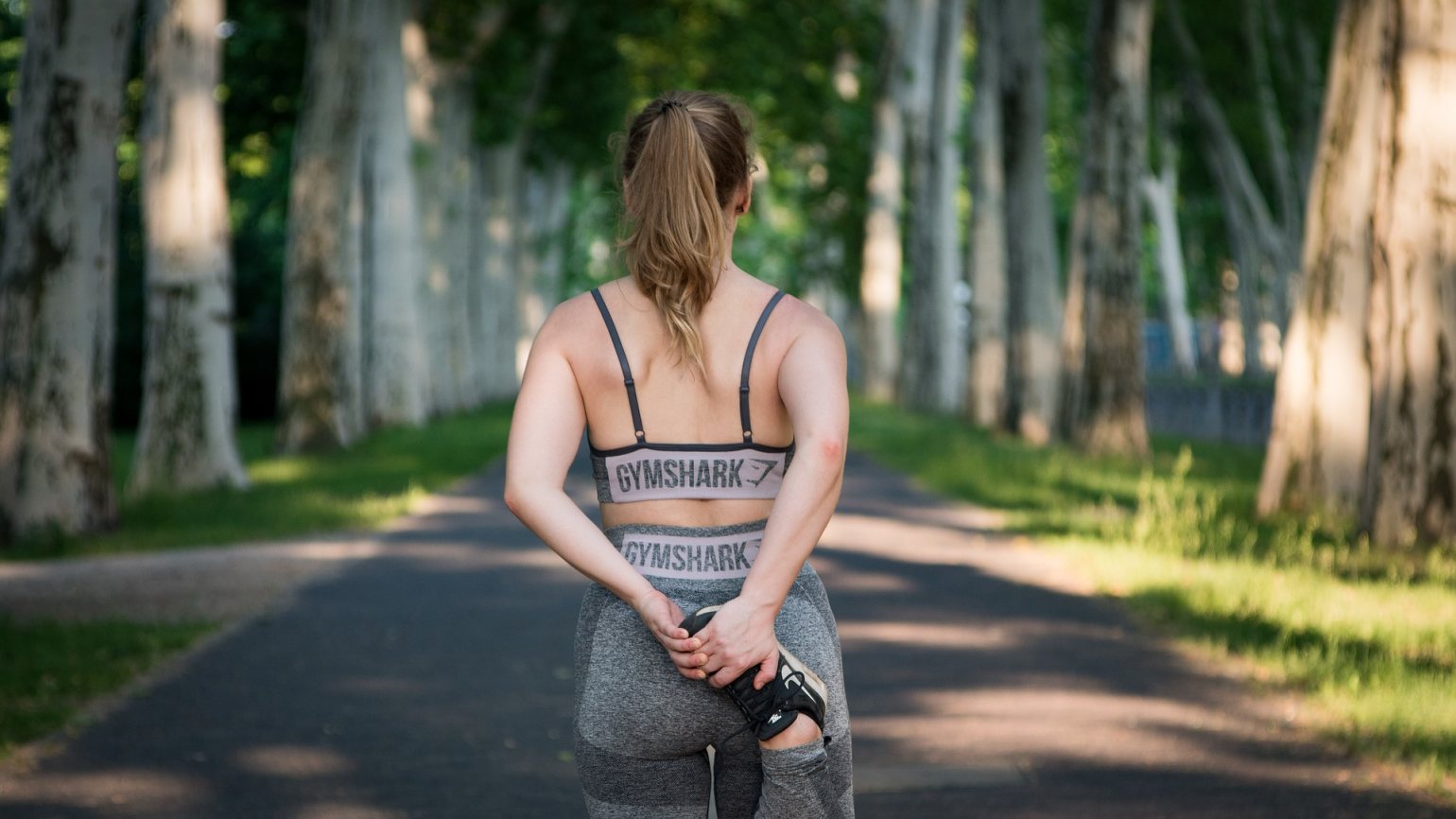 Girl stretching outdoors in Gymshark clothing